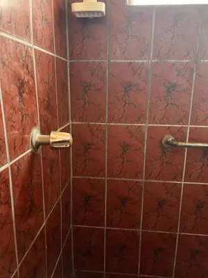 a red tiled shower with a red tile wall at El Descanso in Jacó