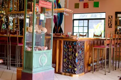 a bar with a bunch of wine bottles at Gingerbread Restaurant & Hotel in Nuevo Arenal