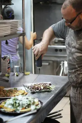 a man standing in a kitchen preparing food at Gingerbread Restaurant & Hotel in Nuevo Arenal