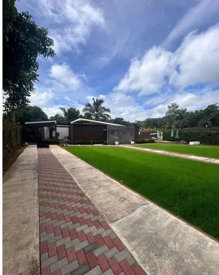 a brick walkway leading to a building with a green lawn at Casa Santoni in Quebrada Ganado
