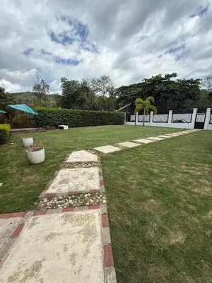 a garden with a white fence and a grass yard at Casa Santoni in Quebrada Ganado