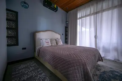 a bedroom with a bed and a window at La Azulada-5min La Fortuna, King beds, pool, BBQ in Fortuna
