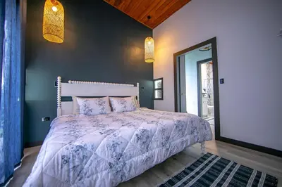 a bedroom with a bed with a white comforter at La Azulada-5min La Fortuna, King beds, pool, BBQ in Fortuna