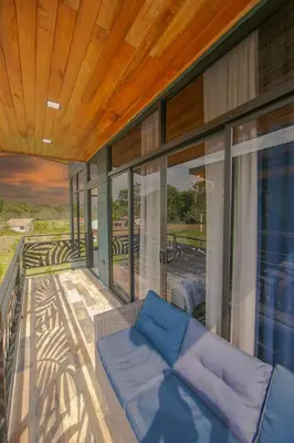 a living room with a couch on a balcony at La Azulada-5min La Fortuna, King beds, pool, BBQ in Fortuna