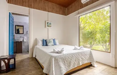 a bedroom with a bed and a large window at Apartamentos Ranas y Ranitas, Apartamento #2 in Fortuna