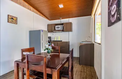 a kitchen with a table and chairs and a refrigerator at Apartamentos Ranas y Ranitas, Apartamento #2 in Fortuna