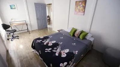 a bedroom with a bed with a black comforter with flowers at Apartamentos Ranas y Ranitas, Apartamento #2 in Fortuna