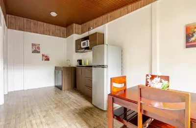 a kitchen with a table and a refrigerator at Apartamentos Ranas y Ranitas, Apartamento #2 in Fortuna