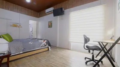 a bedroom with a bed and a desk and a chair at Apartamentos Ranas y Ranitas, Apartamento #2 in Fortuna