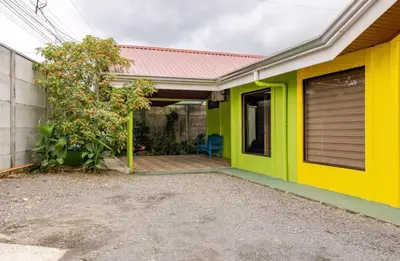 a yellow and green house with a garage at Apartamentos Ranas y Ranitas, Apartamento #2 in Fortuna