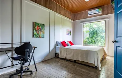 a bedroom with a bed and a desk and a chair at Apartamentos Ranas y Ranitas, Apartamento #2 in Fortuna