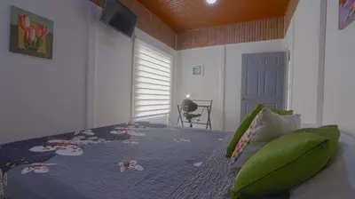 a bedroom with a bed with a blue comforter at Apartamentos Ranas y Ranitas, Apartamento #2 in Fortuna