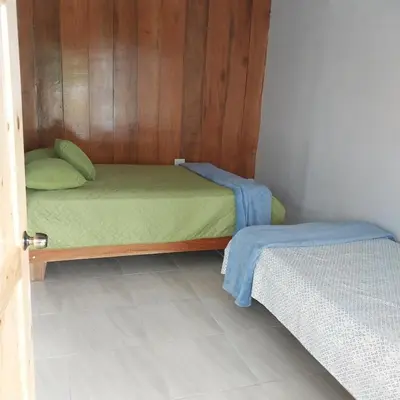a small room with a bed and a door open at Cabaña Gerya in Chachagua