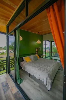 a bed in a room with a green wall at Casa Esmeralda-5min to La Fortuna,King beds & pool in Fortuna