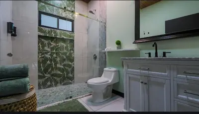 a bathroom with a shower with a toilet and a sink at Casa Esmeralda-5min to La Fortuna,King beds & pool in Fortuna
