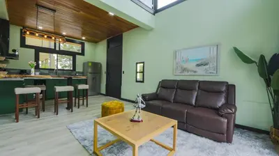 a living room with a couch and a table at Casa Esmeralda-5min to La Fortuna,King beds & pool in Fortuna