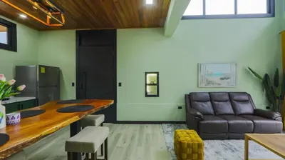 a living room with a couch and a table at Casa Esmeralda-5min to La Fortuna,King beds & pool in Fortuna
