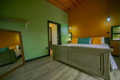a bedroom with a large bed and a mirror at Casa Esmeralda-5min to La Fortuna,King beds & pool in Fortuna
