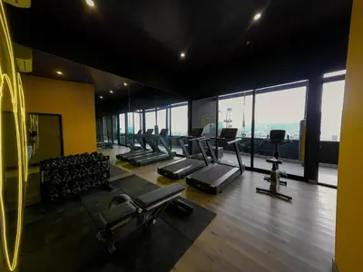 a gym with a bunch of treadmills and chairs at Ser Escalante Modern Studio AC in San José