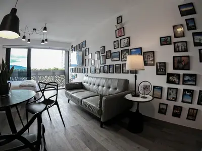 a living room with a couch and pictures on the wall at Ser Escalante Modern Studio AC in San José