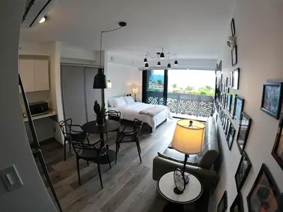 a living room with a bed and a table and chairs at Ser Escalante Modern Studio AC in San José