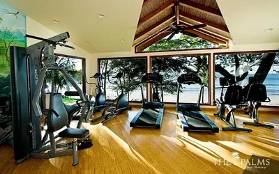 a gym with cardio equipment in a room with windows at Apartment located in The Palms Private in Playa Flamingo, Costa Rica in Portegolpe