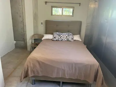 a bedroom with a large bed with a pillow on it at Pura Vida Jungle Retreat - Montezuma in Montezuma