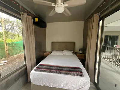 a bedroom with a bed and a large window at Pura Vida Jungle Retreat - Montezuma in Montezuma