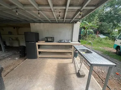 an outdoor kitchen with a table and a stove at Pura Vida Jungle Retreat - Montezuma in Montezuma
