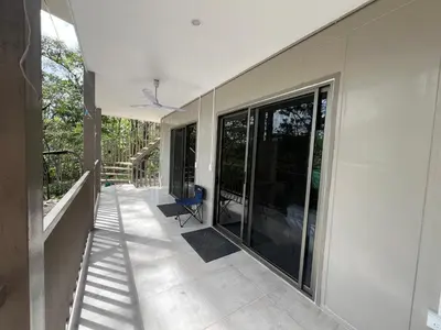 an empty porch of a house with glass doors at Pura Vida Jungle Retreat - Montezuma in Montezuma