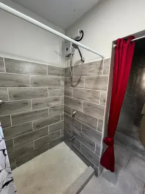 a shower with a red shower curtain in a bathroom at Pura Vida Jungle Retreat - Montezuma in Montezuma