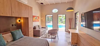 a bedroom with a bed and a living room with a pool at Club Heasa - Men Only in La Garita