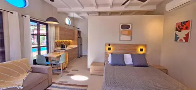 a bedroom with a bed and a couch and a kitchen at Club Heasa - Men Only in La Garita