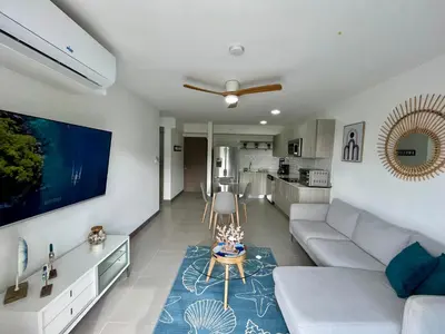 a living room with a couch and a table at Modern Beach Apartment - Walk to Playa Mantas & Beach Club Access in Punta Leona
