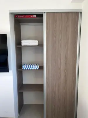 a closet with a wooden door at Modern Beach Apartment - Walk to Playa Mantas & Beach Club Access in Punta Leona