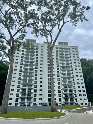 two trees in front of a large apartment building at Modern Beach Apartment - Walk to Playa Mantas & Beach Club Access in Punta Leona