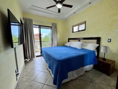 a bedroom with a bed with a blue comforter at Juanderlust - 2 Bedroom Condo in Tamarindo