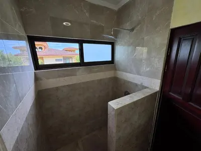 a bathroom with a walk in shower with a window at Juanderlust - 2 Bedroom Condo in Tamarindo