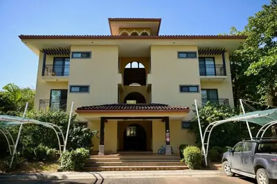 a house with a car parked in front of it at Juanderlust - 2 Bedroom Condo in Tamarindo