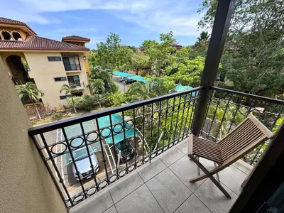a balcony with a bench and a view of a pool at Juanderlust - 2 Bedroom Condo in Tamarindo
