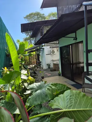 a house with a patio with a bunch of plants at La Casa de Pepa y Poli with Jacuzzi and free bikes in Uvita