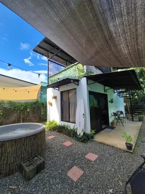 a small house with a hot tub in the backyard at La Casa de Pepa y Poli with Jacuzzi and free bikes in Uvita