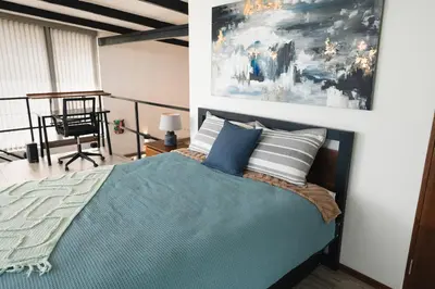 a bedroom with a bed and a painting on the wall at Loft con hermosas vistas y Volcán Turrialba in Turrialba