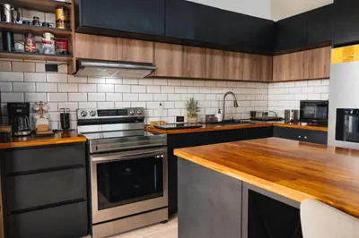a kitchen with stainless steel appliances and wooden cabinets at Loft con hermosas vistas y Volcán Turrialba in Turrialba