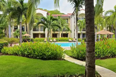 a resort with a swimming pool and palm trees at Luxurious Pacifico 2bed condo in Playa Coco in Coco