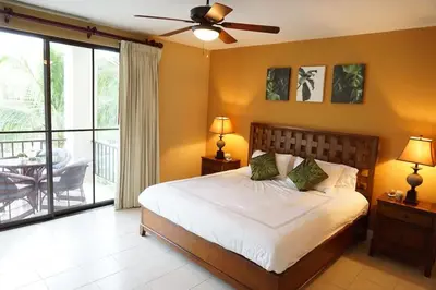 a bedroom with a large bed and a balcony at Luxurious Pacifico 2bed condo in Playa Coco in Coco