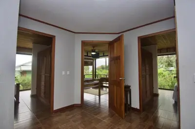 a hallway with doors open to a room at Firefly Hilltop Retreat, Swimming Pool Volcano! in El Castillo de La Fortuna
