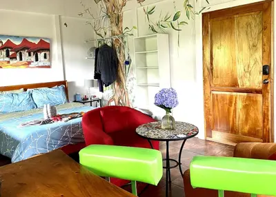 a bedroom with a bed and a table and chairs at Laughing Falcon Studio in El Castillo de La Fortuna