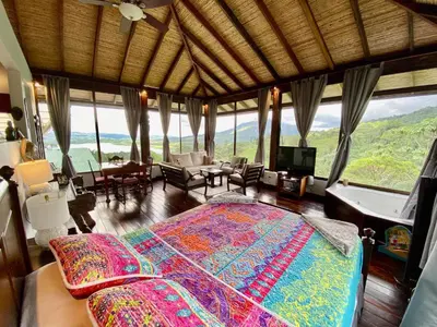 a bedroom with a large bed and a large window at Birdsong Villa, Romantic Suite W- Jacuzzi in El Castillo de La Fortuna
