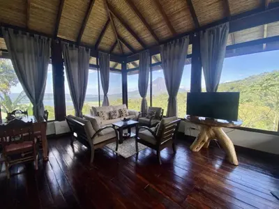 a living room with a tv and a table and chairs at Birdsong Villa, Romantic Suite W- Jacuzzi in El Castillo de La Fortuna